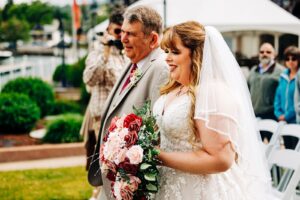 Bride walking down aisle with father at Montana wedding