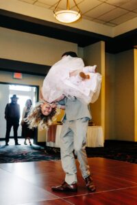 Father swinging daughter in air during father daughter dance at Kwataqnuk Resort