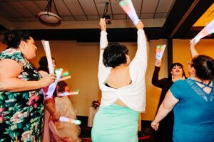 Guests dancing with glow sticks at wedding reception at Kwataqnuk Resort