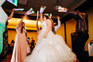 Bride and guests dancing with glow sticks at Kwataqnuk Resort wedding reception