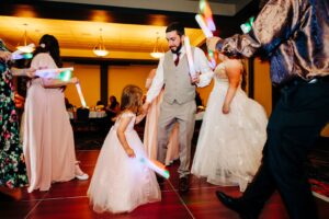 Wedding guests dancing with glow sticks during wedding reception