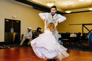 Father swinging daughter around during father daughter dance at Kwataqnuk Resort in Polson, MT