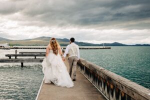 Bride and groom walking down dock at Kwataqnuk Resort at Flathead Lake wedding