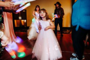 Little girl with glow stick on wedding dance floor at Kwataqnuk Resort in the ballroom