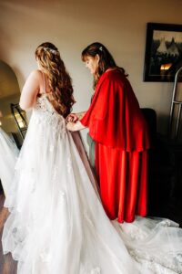 Mother of bride helping bride get dressed in Casino Suite at Kwataqnuk Resort in Polson, MT