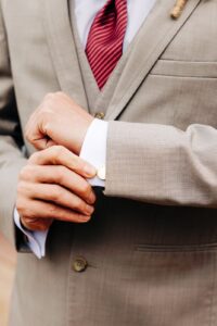 Close up photo of groom adjusting cufflinks