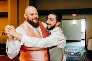 Groom dancing with best man at Kwataqnuk Resort wedding reception