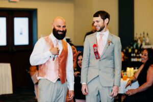 Groomsmen reading ribbons at wedding reception