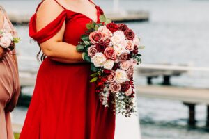 Maid of honor holding bride's flower bouquet at Flathead Lake wedding at Kwataqnuk Resort