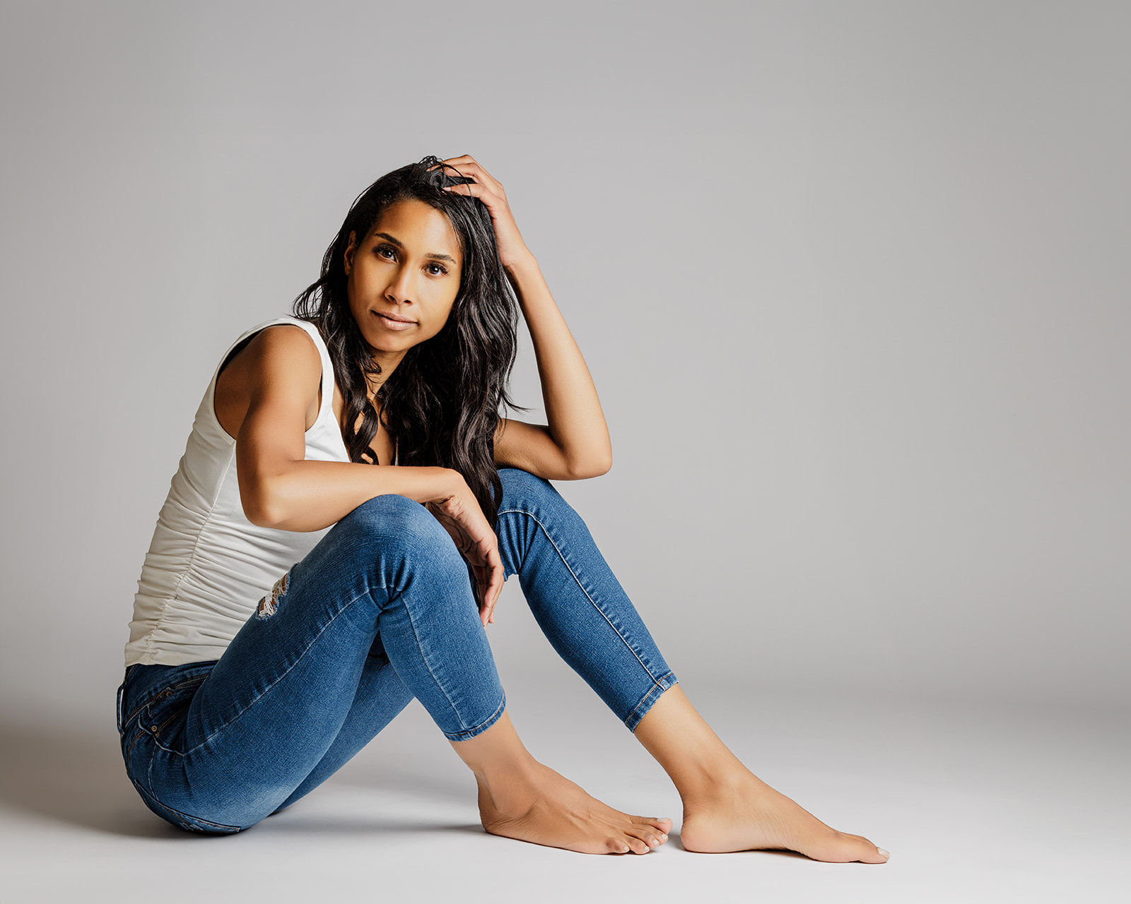 Studio portrait of Montana model wearing blue jeans and white tank top