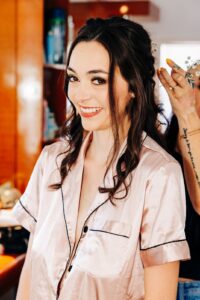 Bride in pink pajamas getting her hair done