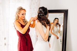 Mother of bride helping bride put on jewelry in bridal suite at Flathead Lake Forevers