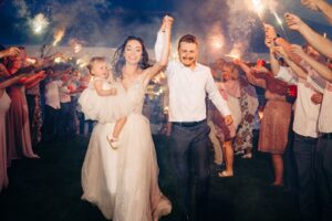 Bride and groom running through sparkler tunnel