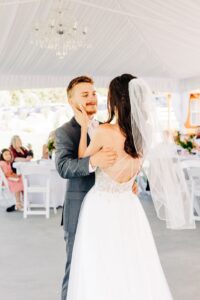 Bride and groom first dance in white reception tent at Flathead Lake Forevers