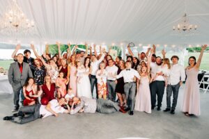 Group photo of all wedding guests in reception tent at Flathead Lake Forevers in Big Arm, MT