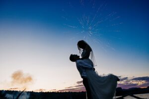 Silhouette of bride and groom embracing under fireworks at Flathead Lake Forevers