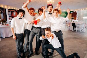 Groom posing with groomsmen at Flathead Lake Forevers wedding reception