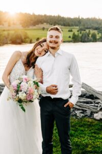 Sunset portrait of bride and groom on shore of Flathead Lake