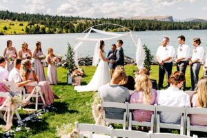 Outdoor wedding ceremony at Flathead Lake Forevers with Flathead Lake and Chief Cliff in background