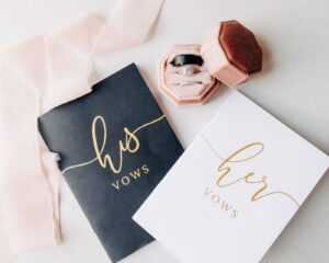 Wedding flat lay of rings and vow books