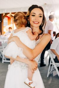 Bride holding baby daughter at wedding reception in Western Montana