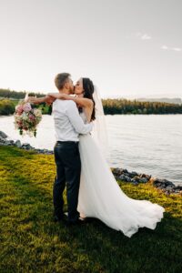 Bride and groom kissing at sunset at Flathead Lake Forevers wedding venue