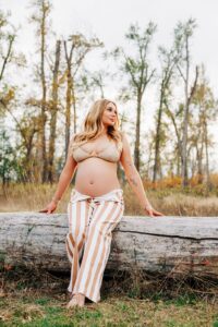 Maternity photo Missoula woman sitting on log at Kelly Island in Missoula
