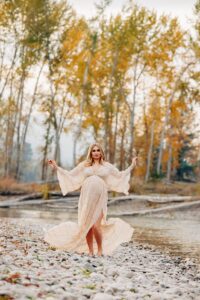 Pregnant woman twirling long dress in the fall at Kelly Island in Missoula, MT
