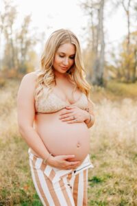 Pregnant Missoula woman standing in field outside