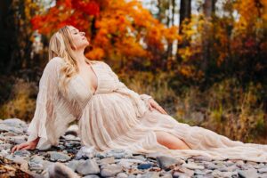 Maternity photo Missoula woman laying on river rocks at Kelly Island