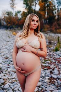 Pregnant Missoula woman in bra and undies standing on river rocks at Kelly Island