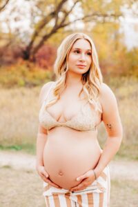 Pregnant woman holding her belly at Kelly Island in Missoula, MT