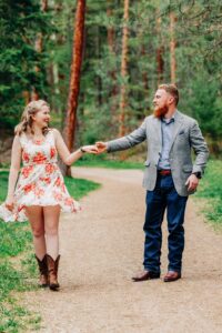 Engagement photo of Missoula couple dancing in forest at Lincolnwood Trailhead
