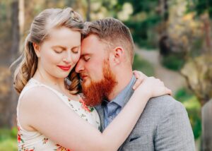 Intimate moment between engaged couple embracing in forest