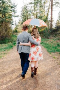 Missoula couple walking arm in arm under colorful umbrella