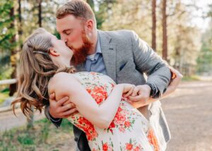 Spring engagement photo Missoula couple dipping and kissing in forest
