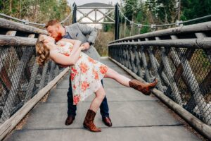 Engagement picture Missoula couple dipping on suspension footbridge