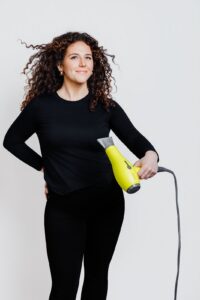 Brand portrait of Missoula Drybar hair stylist holding yellow hair dryer