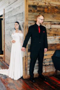 Bride and groom first touch before ceremony upstairs at the Ashley Creek Historic Venue