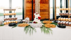 Dessert table with cake, cupcakes, and cookies in the Ashley Creek Historic Venue at Snowline Acres