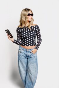 Drybar client with long curly hair holding cell phone in Missoula, MT