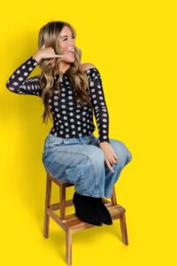 Drybar Missoula female client with long blond hair with curls on yellow backdrop