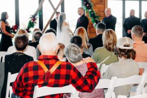 Guests watching indoor wedding ceremony at Ashley Creek Historic Venue in Kalispell, MT