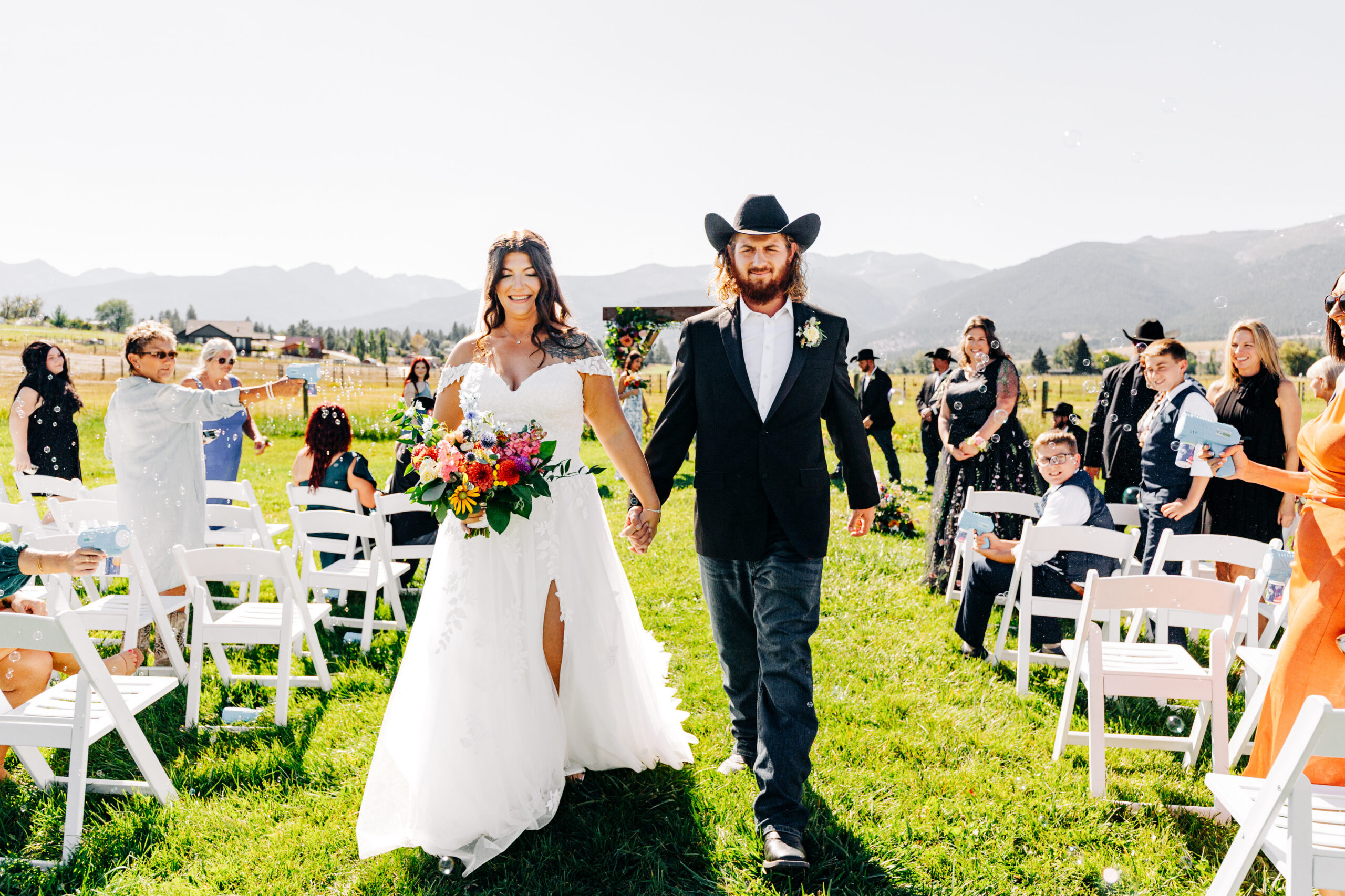 Bride and groom ceremony exit with Bitterroot Mountains at McVey Homestead
