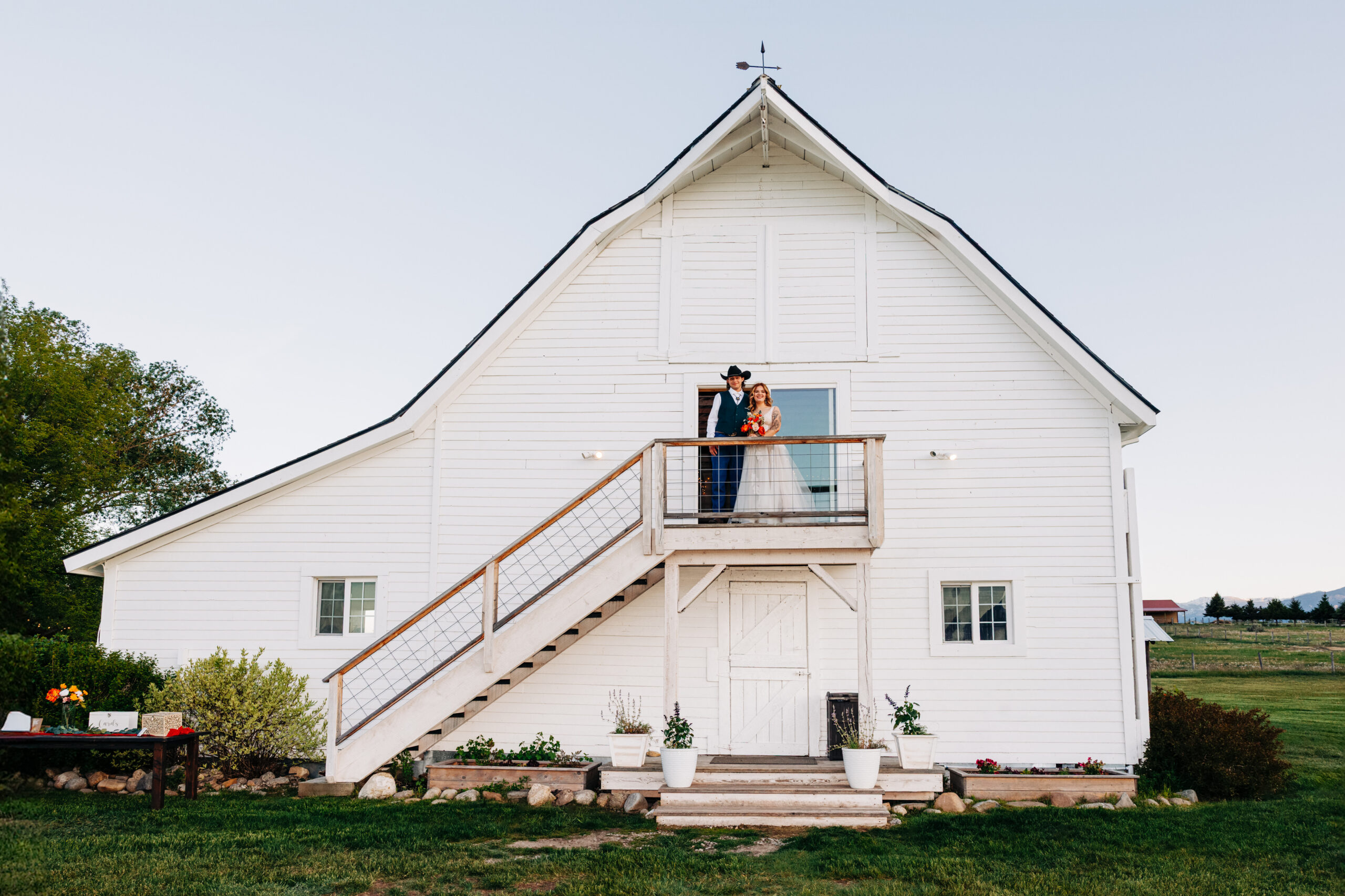 Portrait of bride and groom on white barn at McVey Homestead in Victor,MT