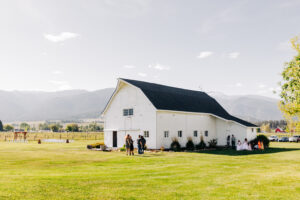 McVey Homestead white barn with Bitterroot Mountains in background in Victor, MT