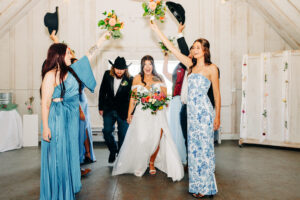 Bride and groom walking through wedding party tunnel inside barn at McVey Homestead