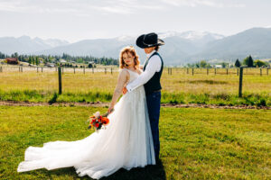 Portrait of bride and groom on grounds of McVey Homestead with Bitterroot Mountains in background