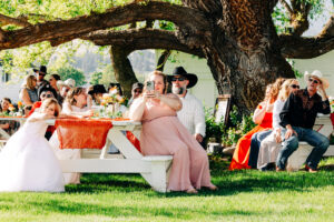 Guests sitting under willow tree shade at McVey Homestead