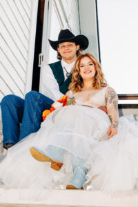 Portrait of bride and groom sitting on staircase of barn at McVey Homestead in Victor, MT